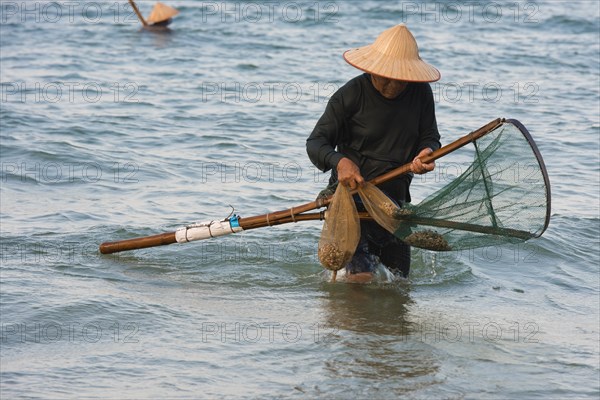 Crabfisher with straw hat in the water