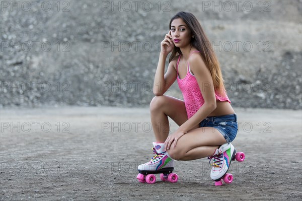 Young woman poses with roller skates