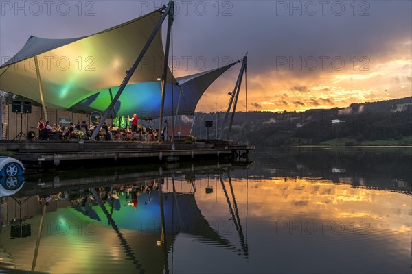 Beach concert at dusk with the band Buhl on the lake stage