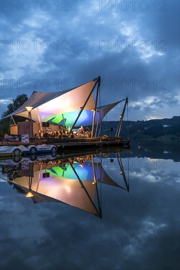 Beach concert at dusk with the band Buhl on the lake stage