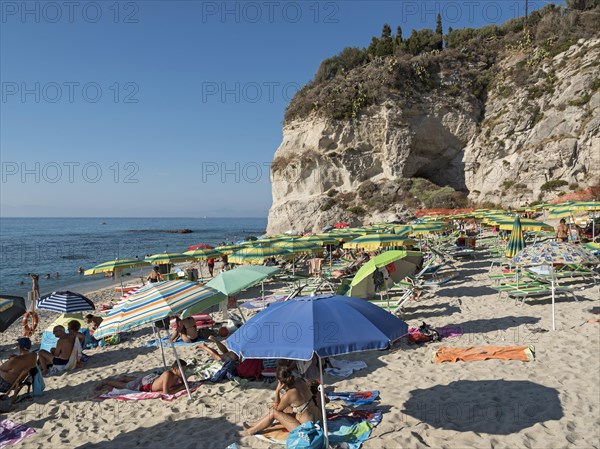 Many people with colorful sunshades at Lido Isola Bella Beach