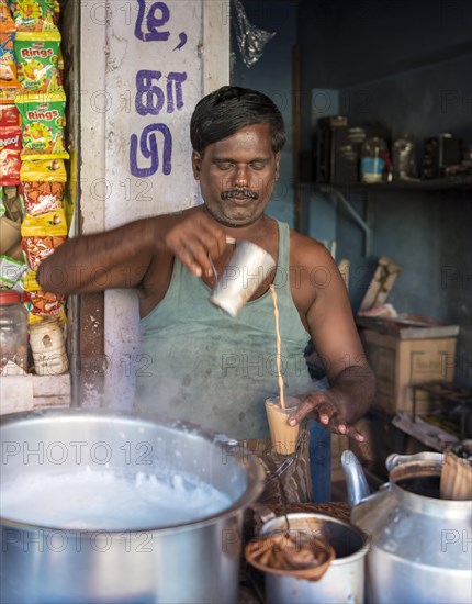 Man makes masala tea at a street stall