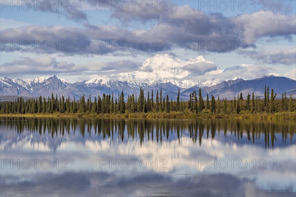 Snowy mountain Denali reflected in the lake with cloudy sky