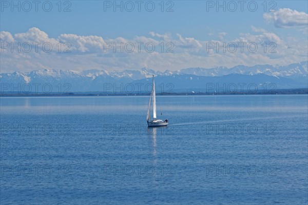Lake Ammer with sailboat and the snow-covered Alpine peaks in the background