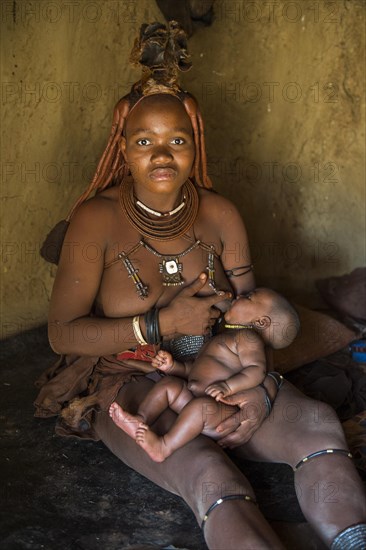 Himba woman breast feeding her baby