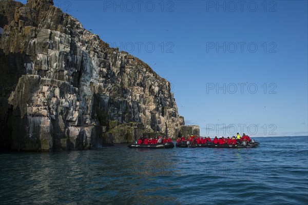 Tourists in zodiacs at cliffs of Alkefjellet