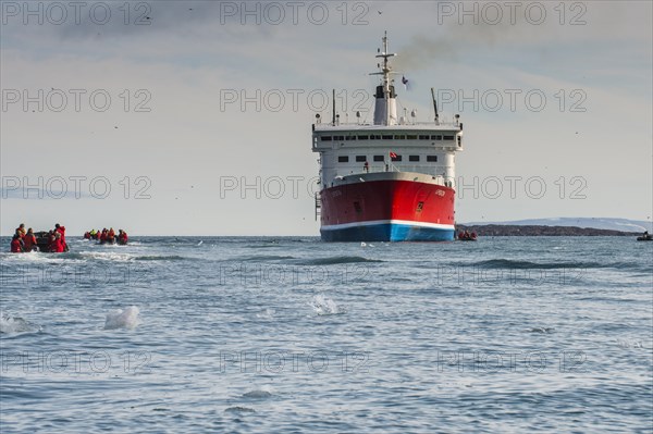 Tourist in zodiacs around a expedition ship