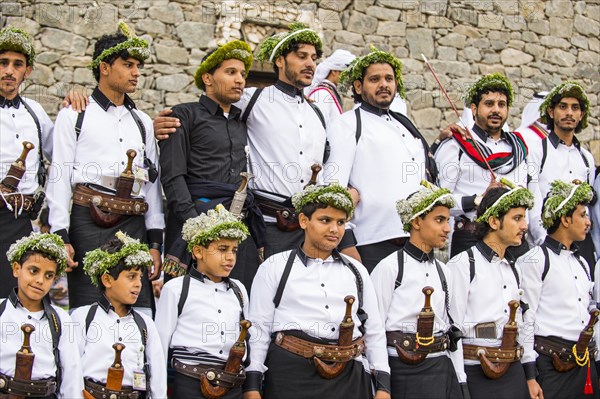 Traditional dressed children and men with with crooked dagger