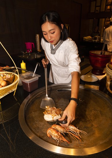 Thai cook preparing pad Thai and prawns