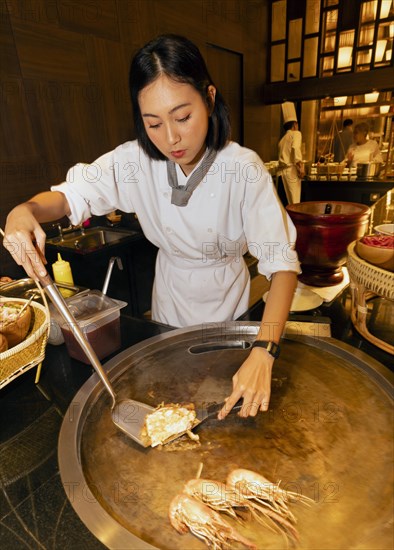 Thai cook preparing pad Thai and prawns