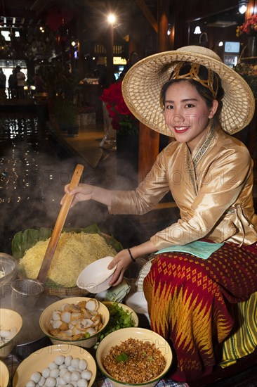 Young woman preparing a noodle soup