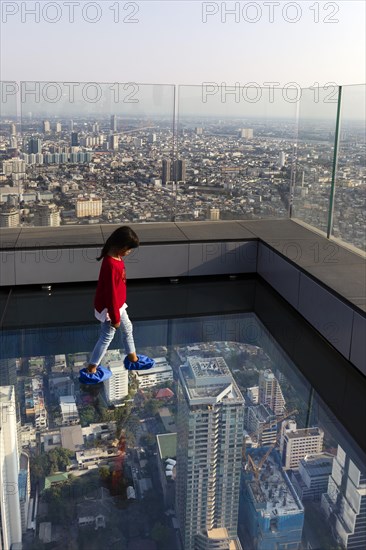 Little girl on the glass skywalk