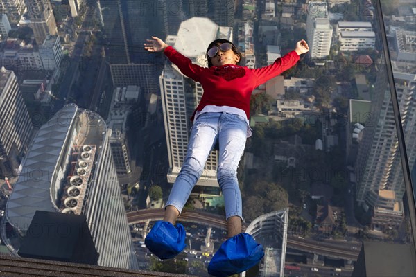 Little girl lies on the glass skywalk