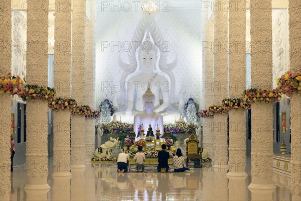 Ornamental columns in the white prayer hall with Buddha statue