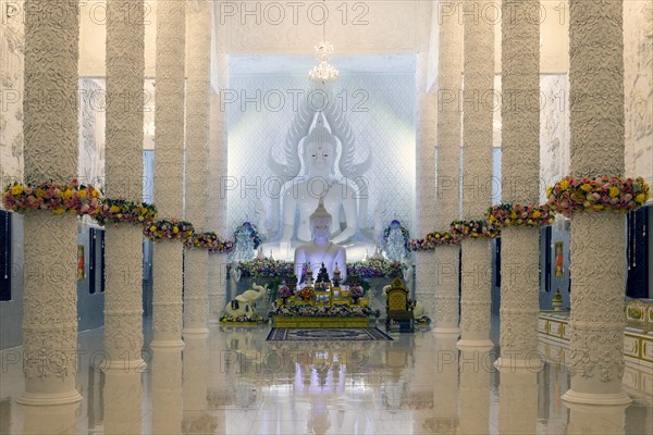 Ornamental columns in the white prayer hall with Buddha statue