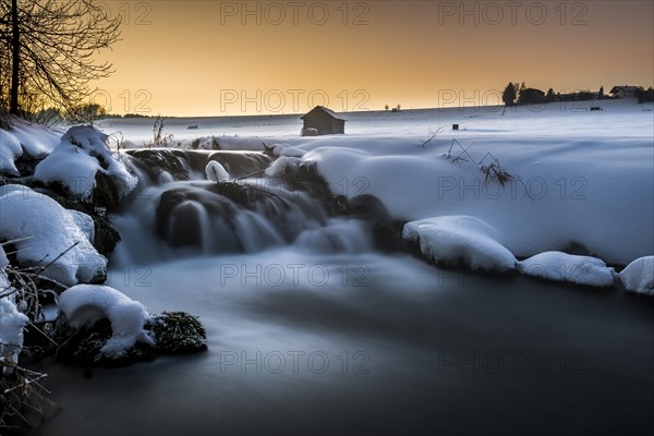 Bach in wintry landscape at sunset