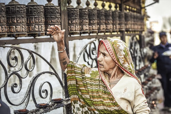 Woman turning prayer mill