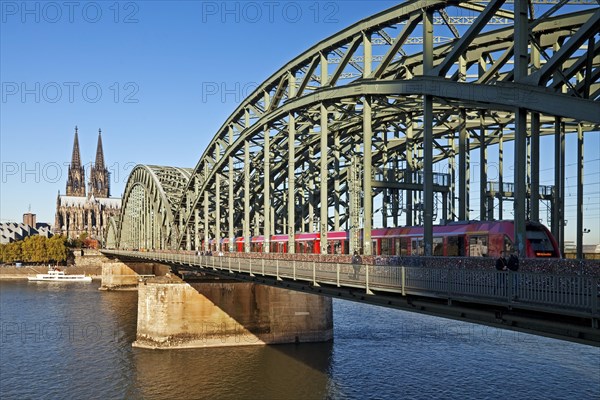 Cologne Cathedral with regional train on the Hohenzollern Bridge and the Rhine River