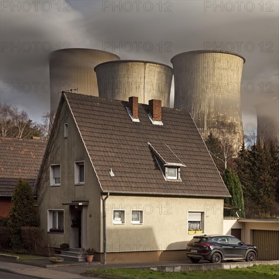 Residence in the Auenheim district in front of the steaming lignite-fired power plant Niederaussem