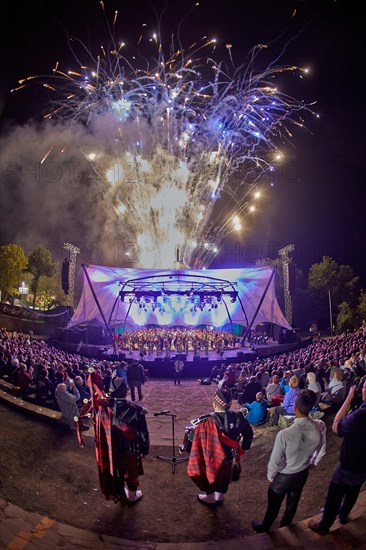 Crowd in front of stage lit with fireworks