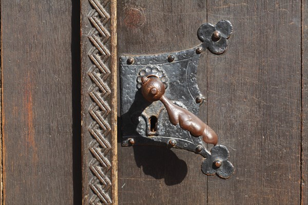 Old doorknob on wooden house door