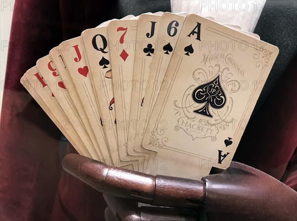 Historical playing cards as fans in a wooden hand