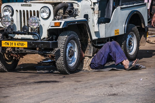 Man laying under Jeep for maintenance