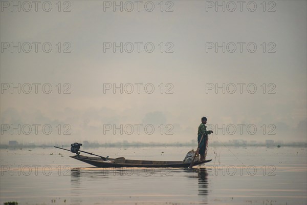 Local fisherman leg rower with wooden boat