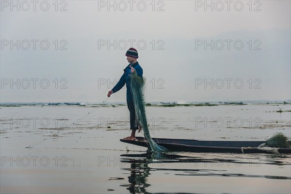 Local fisherman leg rower with wooden boat