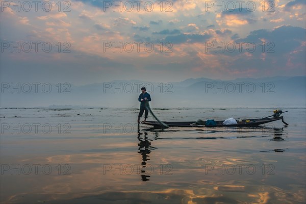 Local Intha fisherman rowing boat with one leg