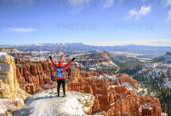 Young woman with outstretched arms and a view of the amphitheatre