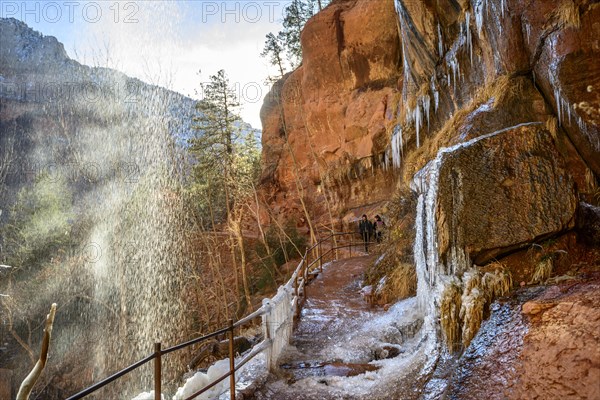 Waterfall falling from overhanging rock in winter