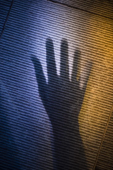 Scary shadow of human hand on stone surface