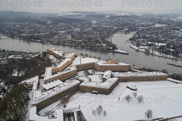 The snow-covered Ehrenbreitstein fortress in Koblenz high above the Deutsches Eck at the confluence of the Rhine and Moselle rivers