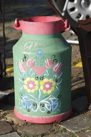 Old colourful milk can at a flea market
