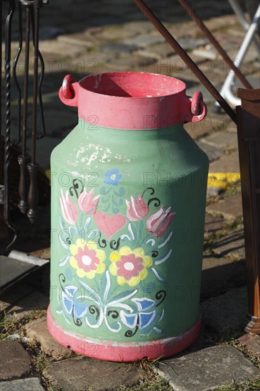 Old colourful milk can at a flea market