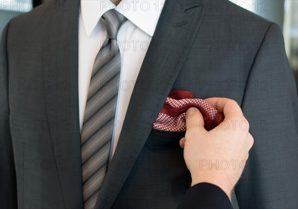 Man in grey jacket with tie and red pocket handkerchief