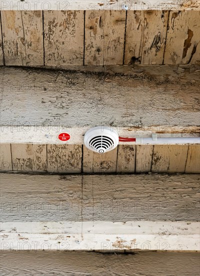 Smoke detector with electrical wiring on old wooden beam
