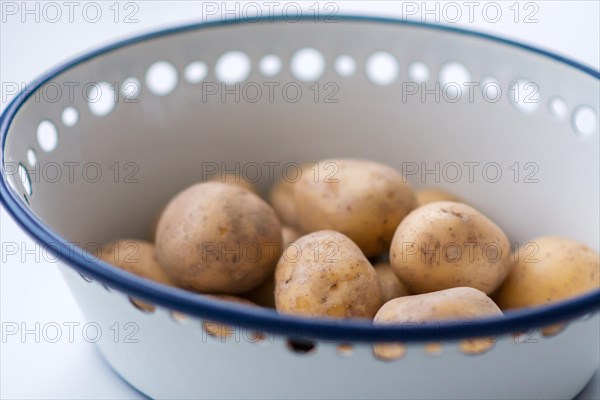 Raw potatoes in a bowl made of enamel