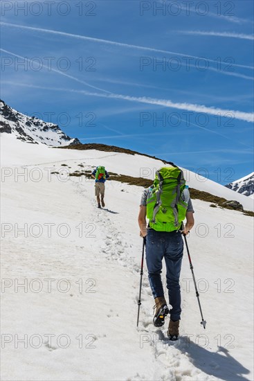 Two hikers walk over snowfield