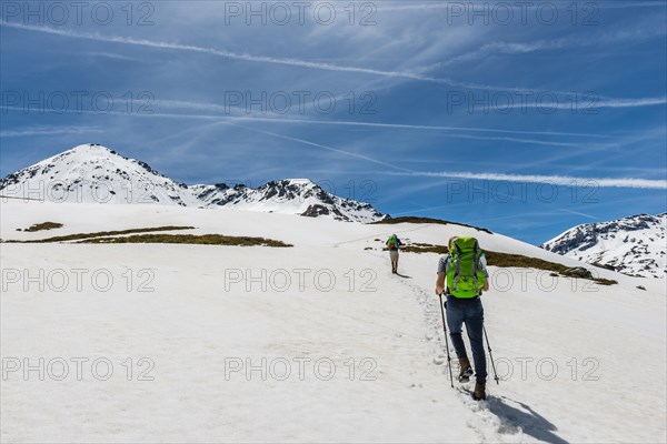 Two hikers walk over snowfield