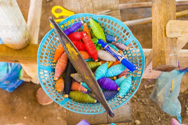 Basket with colorful yarn and needle for weaving