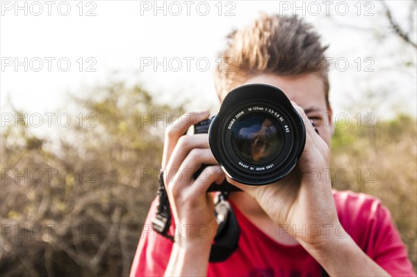 Young man photographing with a SLR