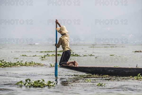 Local fishermen rowing from knees on fishing boat