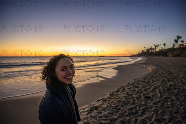 Young woman on the beach at sunset