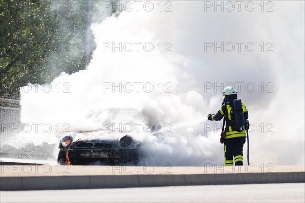 Firefighter extinguishes burning car