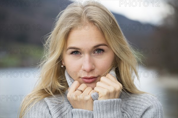 Portrait of a young woman with long blond hair and warm sweater