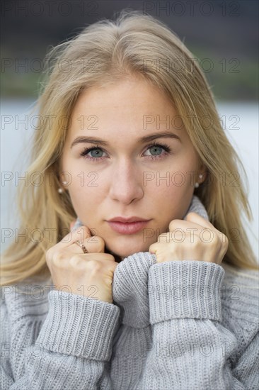 Portrait of a young woman with long blond hair and warm sweater