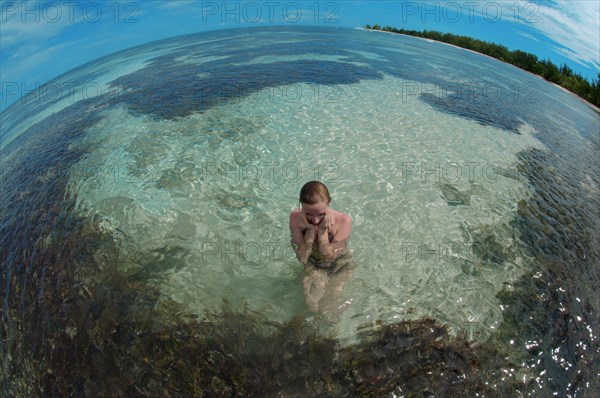 A young woman sitting in water