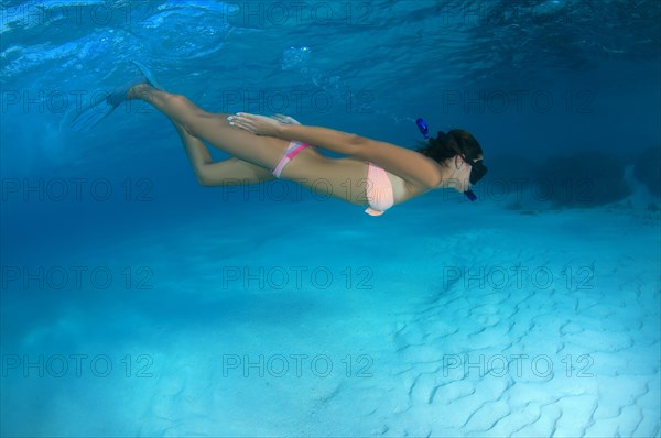 Young woman swimming under water